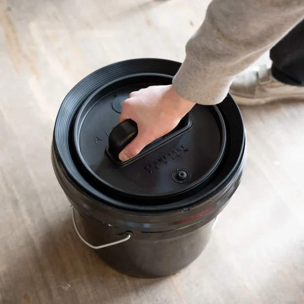 Person putting Bucket Lid Insert in